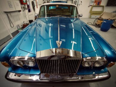 Front of a classic blue Rolls-Royce in the workshop